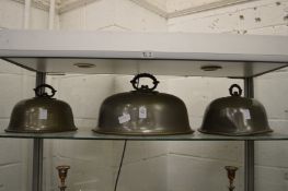 Three pewter meat domes.