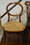 A Victorian mahogany and rush seated balloon back children's chair.