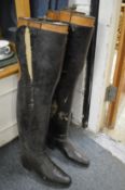 A large pair of black leather boots with boot trees.