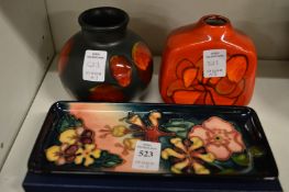 A Moorcroft rectangular pin tray with original box and two Poole pottery vases.
