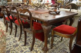 An Edwardian mahogany extending dining table on carved cabriole legs with claw and ball feet.