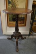 A Victorian walnut circular tripod table with unusual wrythen fluted column support.