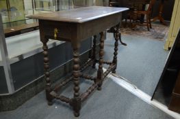 An oak rectangular table with a drawer to each end on turned supports.