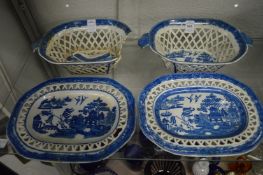 A pair of blue and white willow pattern twin handled pierced baskets on stands (one basket and stand