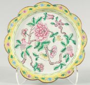 A CHINESE CANTON ENAMEL DISH, with petal form rim, painted with flowers and pomegranate, 25cm