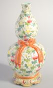 A CHINESE FAMILLE ROSE PORCELAIN DOUBLE GOURD VASE, decorated with gourds and moulded ribbon to