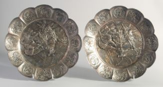 A PAIR OF JAPANESE EMBOSSED PETAL FORM WHITE METAL DISHES, each with central panel depicting