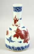 A CHINESE BLUE, WHITE, AND UNDERGLAZE RED BOTTLE VASE decorated with a dragon amongst stylised