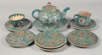 A PALESTINIAN TURQUOISE GLAZE POTTERY PART TEA SET, each piece painted with floral decoration,