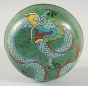 A CHINESE GREEN GROUND CLOISONNE CIRCULAR BOX, decorated with a dragon, 11cm diameter.