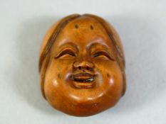 A SMALL CARVED WOOD NETSUKE, okame mask, 2.5cm.