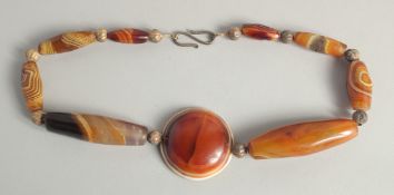 A GOOD AGATE BEADED NECKLACE, with different shaped beads and large circular pendant.