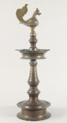 A LARGE INDIAN BRONZE OIL LAMP, the top with bird formed finial, 62cm high.