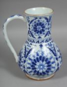 A TURKISH KUTAHYA BLUE AND WHITE GLAZED WATER JUG, painted with stylised flower heads, (AF), 22cm