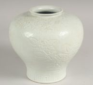 A GOOD CHINESE BULBOUS WHITE PORCELAIN VASE decorated with flowers, leaves and scrolls in relief. 7