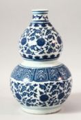 A CHINESE BLUE AND WHITE DOUBLE GOURD VASE, painted with lotus flowers, 27cm high.