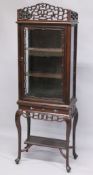 A GOOD CHINESE ROSEWOOD CABINET ON STAND, the top with a pierced cornice, glazed door and sides