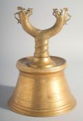 AN ISLAMIC TURKISH BRASS CANDLESTICK, with twin dragon heads, 26.5cm high.