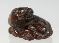 A JAPANESE CARVED WOODEN NETSUKE of a mythological beast, 4cm wide.