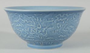 A CHINESE POWDER BLUE GLAZE PORCELAIN BOWL, the exterior with carved dragon, six-character mark to
