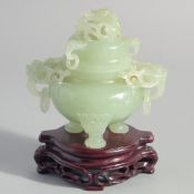 A CHINESE CARVED JADE TWIN HANDLE CENSER AND COVER on a fitted hardwood stand, the cover and