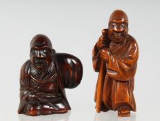 TWO JAPANESE CARVED WOODEN NETSUKES, one of a figure holding a staff, 5cm, the other of a seated