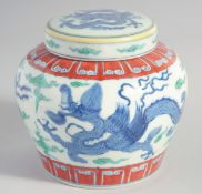 A CHINESE MING STYLE DOUCAI PORCELAIN JAR AND COVER, painted with dragons, 13.5cm high.