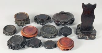 A COLLECTION OF TWELVE CHINESE CARVED HARDWOOD STANDS, various sizes, (12).