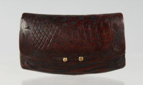 A JAPANESE CARVED WOODEN NETSUKE of a closed purse, with two metal pins to the front, 4.5cm wide.