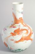A CHINESE CORAL RED AND WHITE PORCELAIN VASE, painted with a dragon above stylised waves, six-