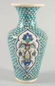 AN IZNIK STYLE TURQUOISE GLAZE POTTERY VASE, painted with panels of floral motifs, 26cm high.