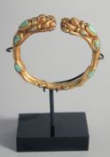 A TIBETAN BRACELET, inset with turquoise stones, with stand.