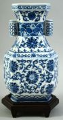 A CONTEMPORARY CHINESE BLUE AND WHITE PORCELAIN TULIP VASE AND STAND, painted with foliate design,