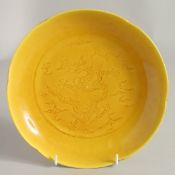 A CHINESE YELLOW GLAZE PORCELAIN DRAGON DISH, with petal form rim and incised dragon to the