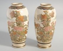 A PAIR OF JAPANESE SATSUMA VASES, painted with native flora and mountains with gilt highlights, base