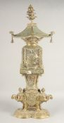 A TALL EAST ASIAN FOUR-PIECE BRASS LANTERN, in the form of a bird cage upon a figural base of
