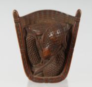A JAPANESE CARVED WOODEN NETSUKE of a quail stood in a basket, 5cm wide.