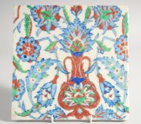 AN IZNIK STYLE GLAZED POTTERY TILE, painted with foliate motifs, 24.5cm square.