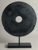 A LARGE CHINESE BLACK MARBLE BI DISK, raised on stand, disk 40.5cm diameter.