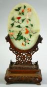 A CHINESE JADE AND HARD STONE OVAL TABLE SCREEN ON WOODEN STAND, the carved jade plaque onlaid