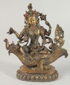 A GOOD BRONZE FIGURE OF A MULTI-ARM DEITY, inset with stones, the figure seated upon an aquatic