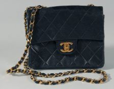 A USED CHANEL BLACK PADDED LEATHER BAG, with long gilt and leather handle. 6.5ins long, 5ins deep.