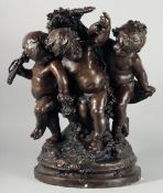 A LARGE BRONZE GROUP OF THREE CHERUBS on a circular base.