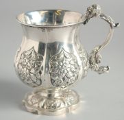 A GEORGE III SILVER TANKARD with six repousse floral panels.