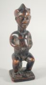 A GOOD CARVED WOOD TRIBAL SEATED FIGURE. 9ins high.