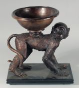 A BRONZE OF A MONKEY a bowl on its back. 15ins high.