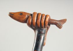 A FOLK ART WALKING STICK, a hand holding a fist.