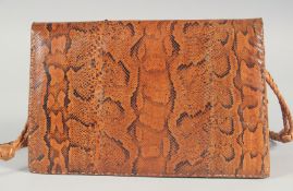 A 1940's - 1950's SNAKESKIN HANDBAG with fold over flap, leather fitted interior and long entwined