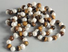 A STRING OF PEARL AND TIGERS EYE BEADS.