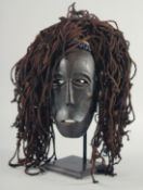 A TRIBAL MASK on a stand.